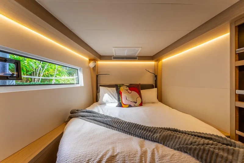 Slide: The Image of 2024 Lagoon 51 yacht bedroom with modern design and ambient lighting. - 71