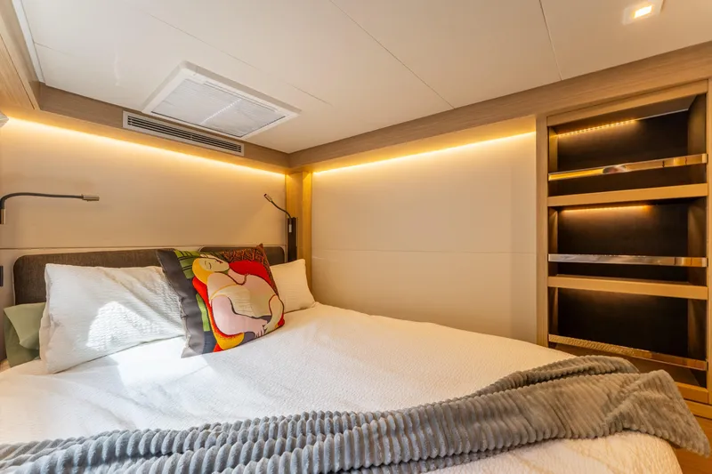 Slide: The Image of Luxurious bedroom interior of 2024 Lagoon 51 yacht with modern lighting and cozy bedding. - 72