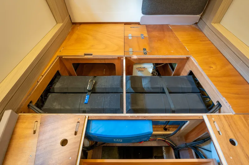 Slide: The Image of 2024 Lagoon 51 yacht interior showing battery storage compartment with wooden panels. - 73