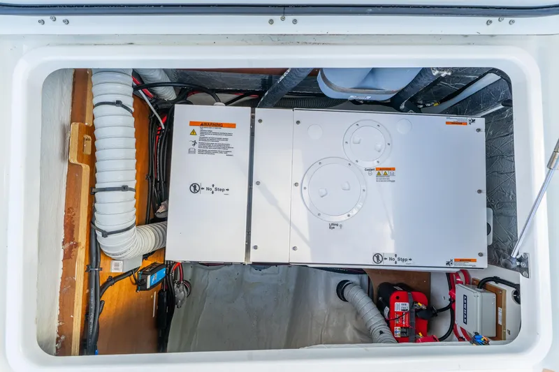 Slide: The Image of Engine compartment of 2024 Lagoon 51 yacht, showcasing mechanical components and wiring. - 77