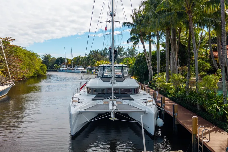 Slide: The Image of 2024 Lagoon 51 catamaran docked in a tropical marina setting. - 86