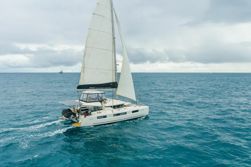 Slide: The Image of 2024 Lagoon 51 catamaran sailing on open sea under cloudy skies. - 89