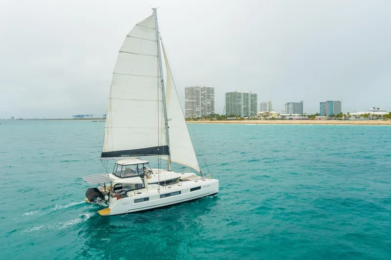 Slide: The Image of 2024 Lagoon 51 catamaran sailing near city skyline on a clear day. - 94