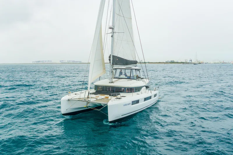 Slide: The Image of 2024 Lagoon 51 catamaran sailing on open sea with clear skies. - 98
