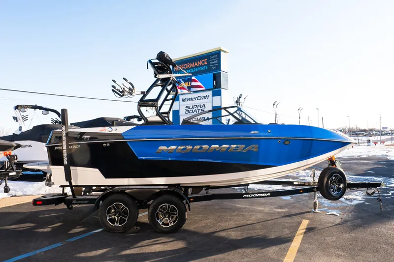 Slide: The Image of 2021 Moomba Mondo boat in blue and black on a trailer at a dealership. - 7