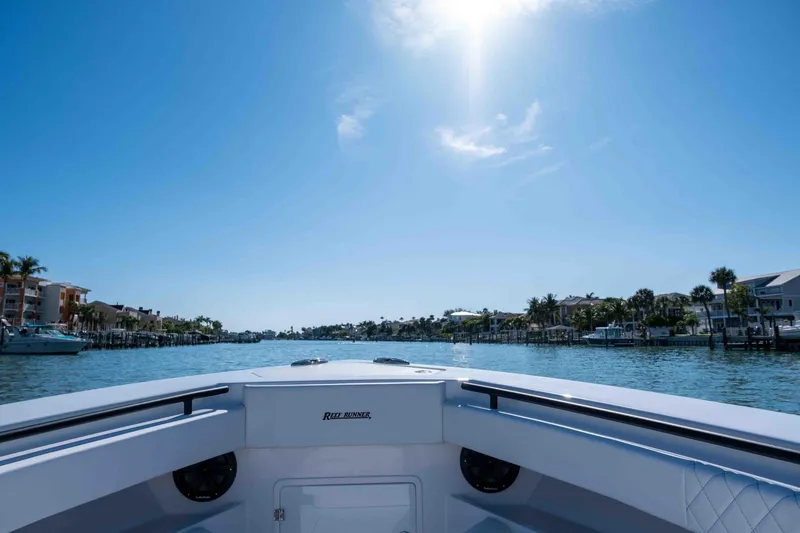Slide: The Image of Reef Runner 340 boat on sunny waterway, 2026 model. - 19