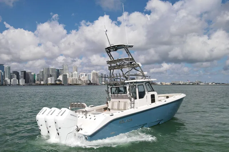 Slide: The Image of Manufacturer Provided Image: 2026 Solace 37 PILOT boat cruising near city skyline under cloudy sky. - 1