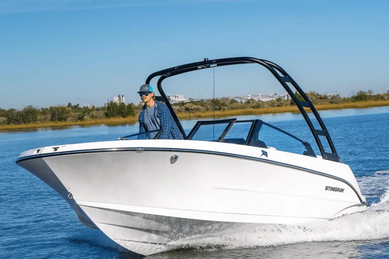 Slide: The Image of Manufacturer Provided Image: 2026 Stingray 20 SBX boat cruising on a calm lake with a driver. - 1