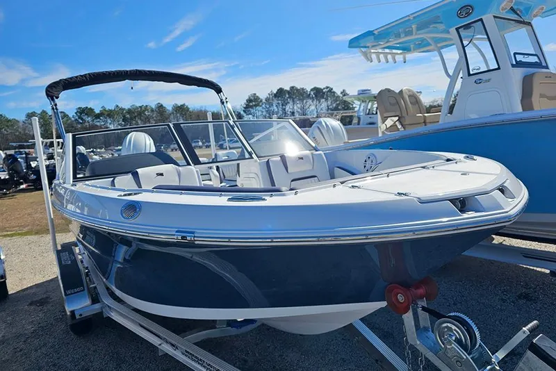 Slide: The Image of 2026 Stingray 20 SBX boat on trailer, displayed outdoors under clear blue sky. - 6