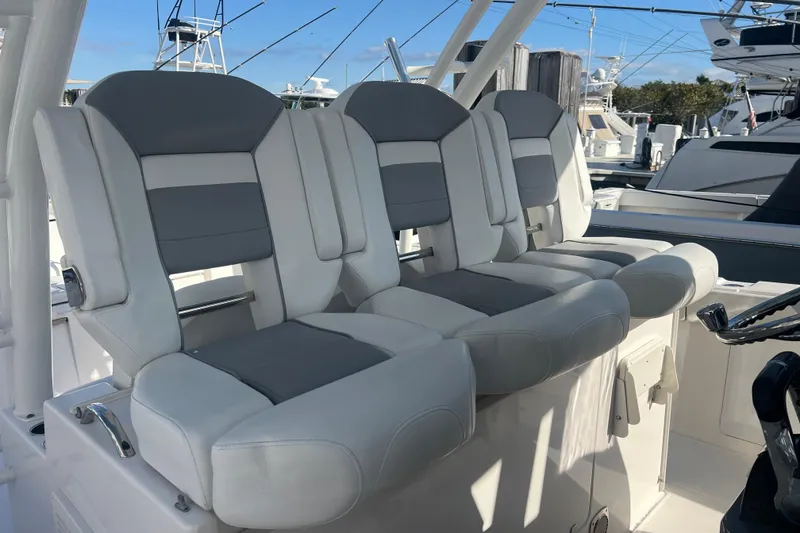 Slide: The Image of 2019 Pursuit S 368 Sport boat seats, gray and white upholstery, docked at marina. - 13