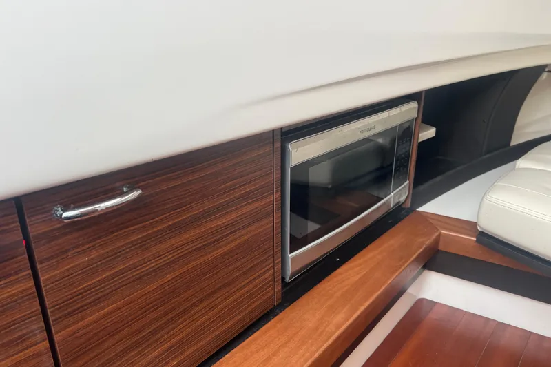 Slide: The Image of 2019 Pursuit S 368 Sport interior with microwave and wooden cabinetry. - 34