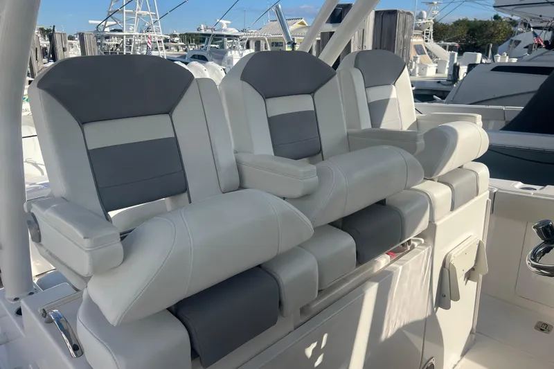 Slide: The Image of 2019 Pursuit S 368 Sport boat seats, gray and white, in a marina setting. - 43