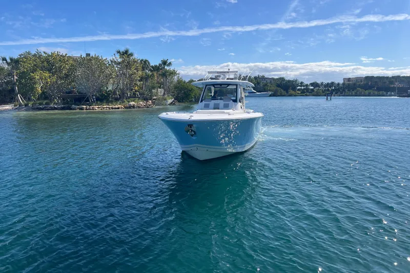 Slide: The Image of 2019 Pursuit S 368 Sport boat cruising on clear blue water. - 5