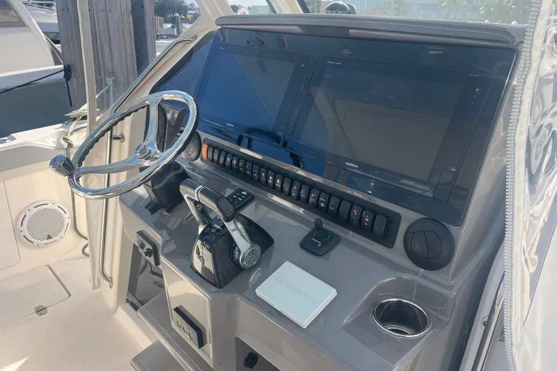 Slide: The Image of 2019 Pursuit S 368 Sport boat helm with dual screens and controls. - 50