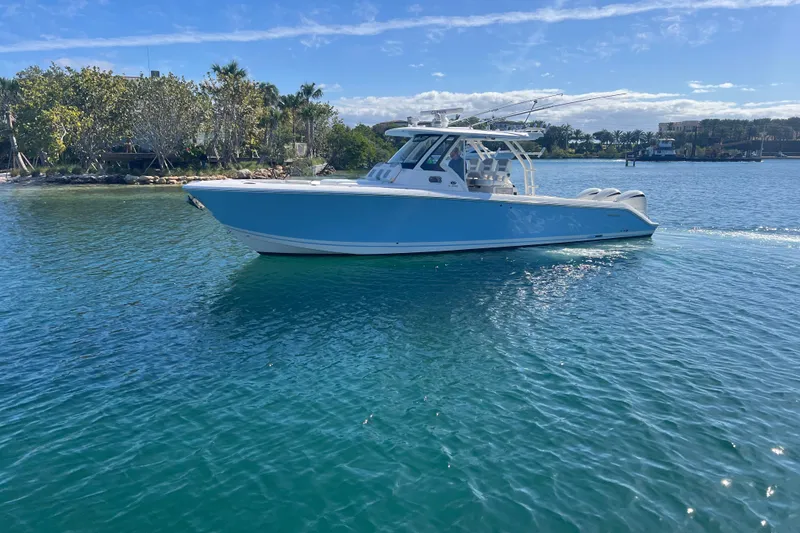 Slide: The Image of 2019 Pursuit S 368 Sport boat cruising on clear blue water. - 7