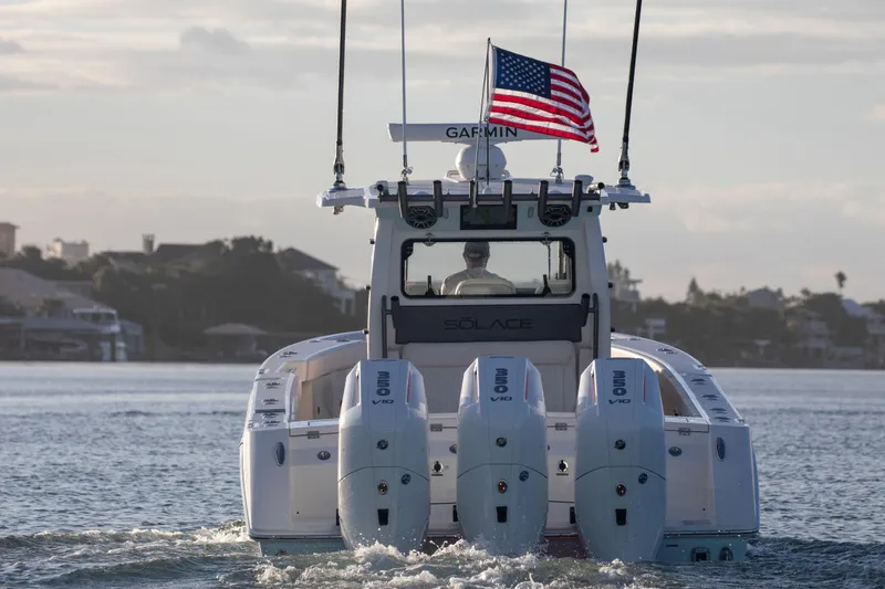 Slide: The Image of 2026 Solace 35 CS boat with triple engines, American flag, cruising on calm water. - 3