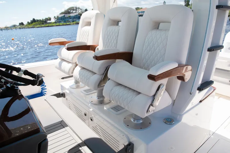Slide: The Image of Luxury seating on 2026 Solace 35 CS boat, featuring plush white upholstery and wooden armrests. - 4