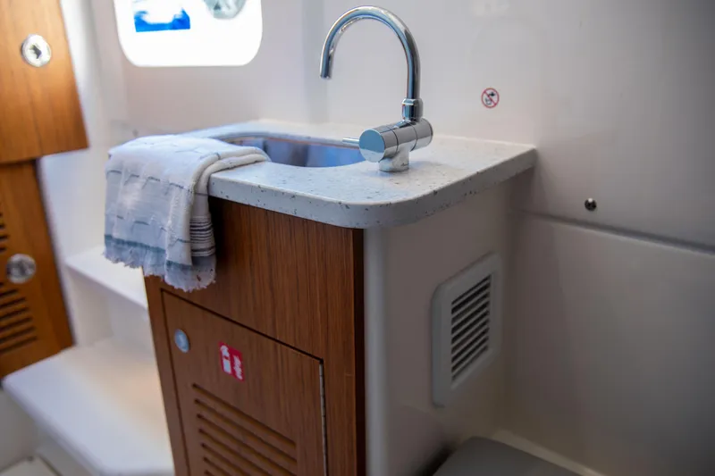 Slide: The Image of Compact sink area in 2026 Solace 35 CS boat, featuring modern faucet and wooden cabinetry. - 7