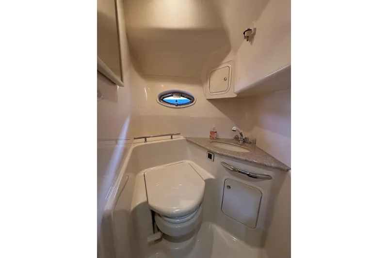 Slide: The Image of 2003 Sea Ray 420 Sundancer bathroom with compact design and oval window. - 10