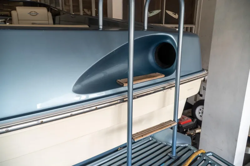 Slide: The Image of 1997 Magnum 56 boat stern with ladder and blue detailing in a garage. - 16