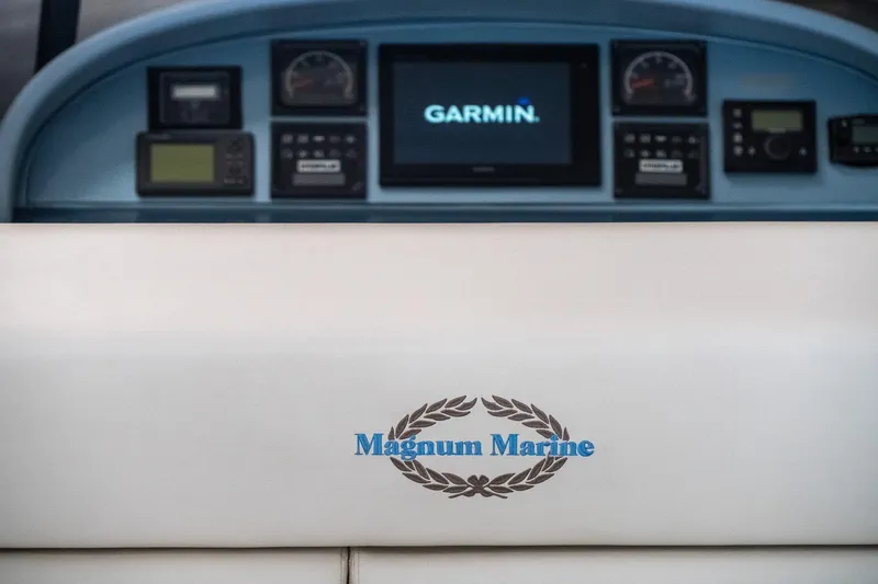 Slide: The Image of 1997 Magnum 56 boat dashboard with Garmin navigation system and Magnum Marine logo. - 17