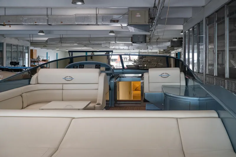 Slide: The Image of Luxurious 1997 Magnum 56 yacht interior with plush seating in a modern showroom. - 2