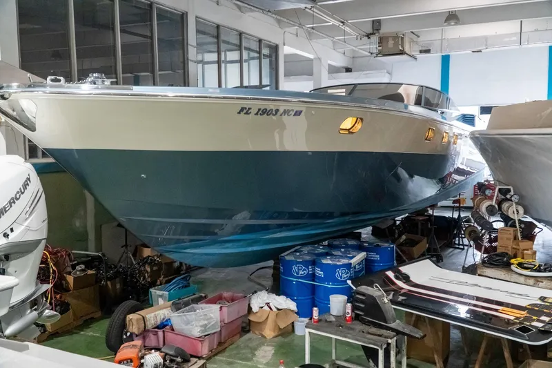 Slide: The Image of 1997 Magnum 56 boat in a workshop, surrounded by equipment and supplies. - 21