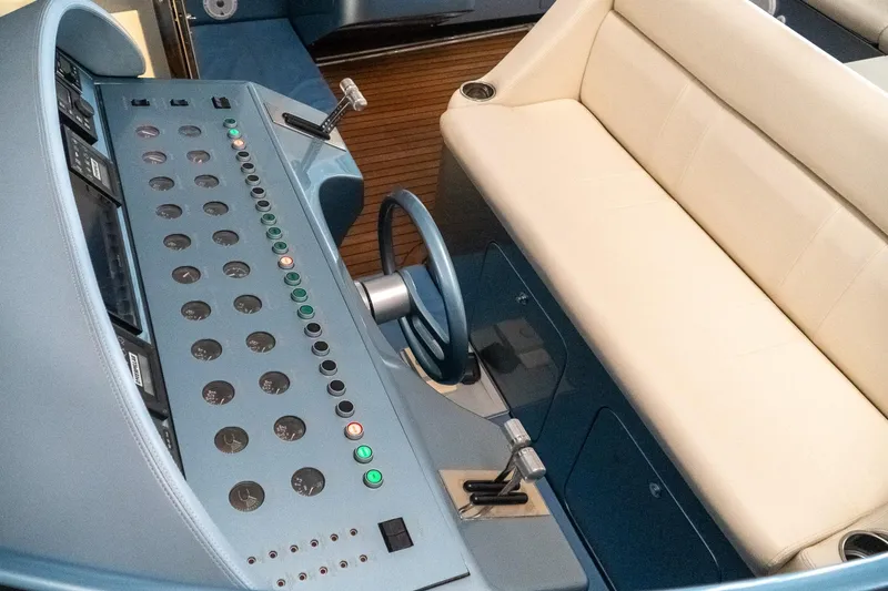 Slide: The Image of Control panel of a 1997 Magnum 56 yacht with beige seating and blue dashboard. - 25