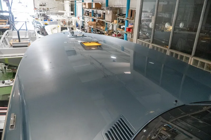 Slide: The Image of 1997 Magnum 56 yacht in a workshop, showcasing sleek design and reflective surface. - 26