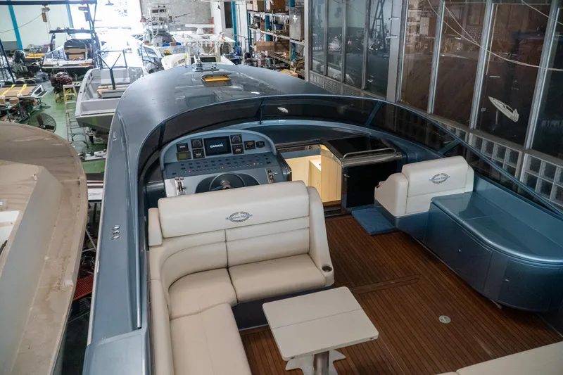 Slide: The Image of Luxurious 1997 Magnum 56 yacht interior with elegant seating and modern dashboard in a workshop. - 29