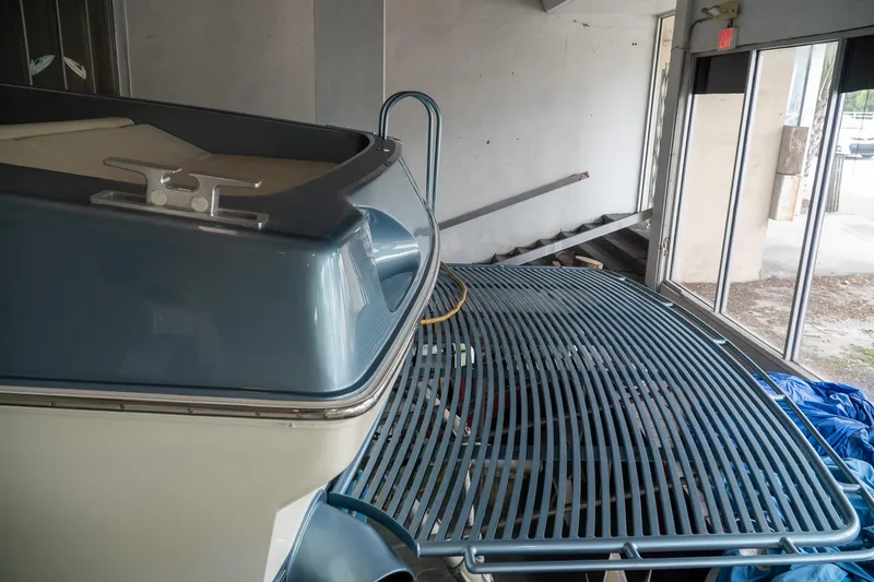 Slide: The Image of 1997 Magnum 56 boat in storage, featuring a sleek blue and white design. - 39