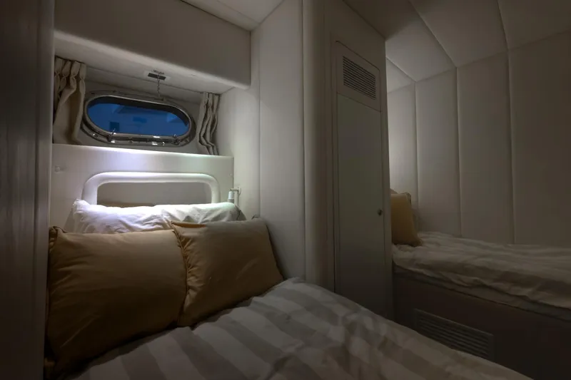 Slide: The Image of Cozy cabin interior of 1997 Magnum 56 yacht with twin beds and porthole window. - 51