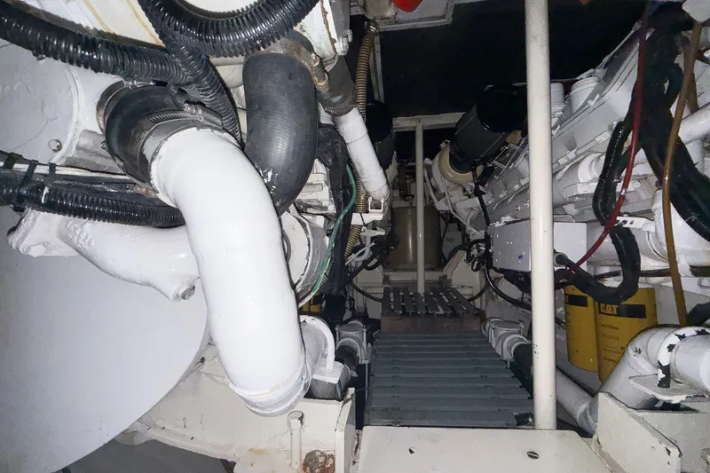 Slide: The Image of Engine room of a 1997 Magnum 56 yacht, featuring pipes and mechanical components. - 59