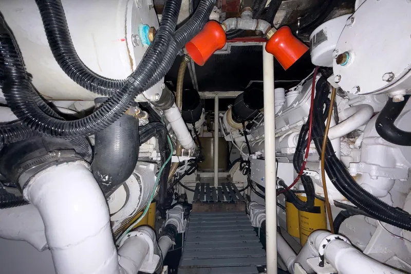 Slide: The Image of Engine room of a 1997 Magnum 56 yacht, featuring complex machinery and piping. - 60