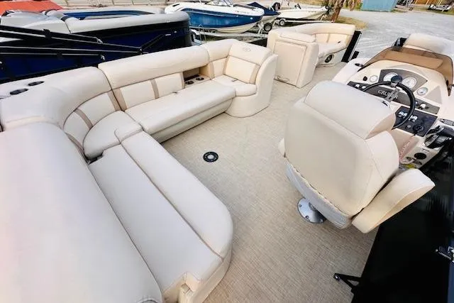 Slide: The Image of 2019 Harris Cruiser 250 boat interior with beige seating and steering console. - 11