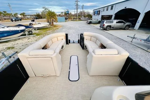 Slide: The Image of 2019 Harris Cruiser 250 pontoon boat with beige seating, parked near a marina. - 12