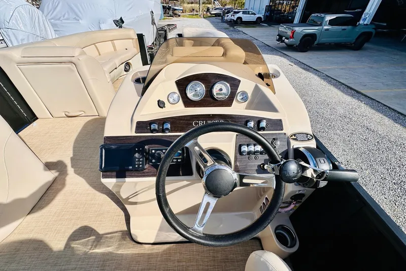 Slide: The Image of 2019 Harris Cruiser 250 boat dashboard with steering wheel and control panel. - 13