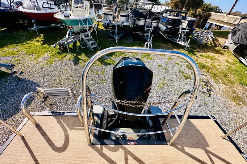 Slide: The Image of 2019 Harris Cruiser 250 boat with Mercury engine, docked among other boats. - 17