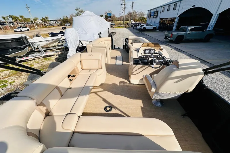 Slide: The Image of 2019 Harris Cruiser 250 pontoon boat with beige seating and modern dashboard. - 19