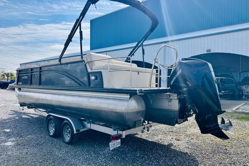 Slide: The Image of 2019 Harris Cruiser 250 pontoon boat on trailer with Mercury outboard motor. - 2