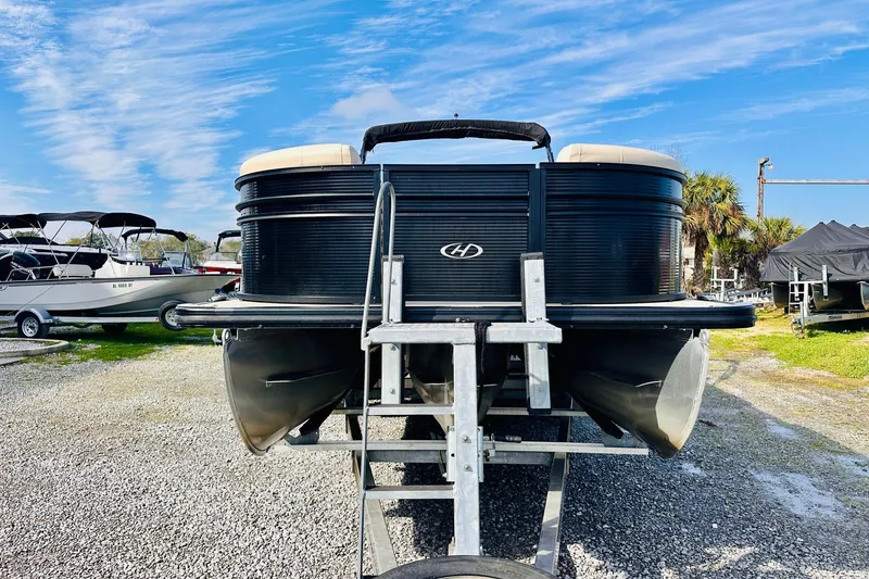Slide: The Image of 2019 Harris Cruiser 250 pontoon boat on trailer under blue sky. - 6
