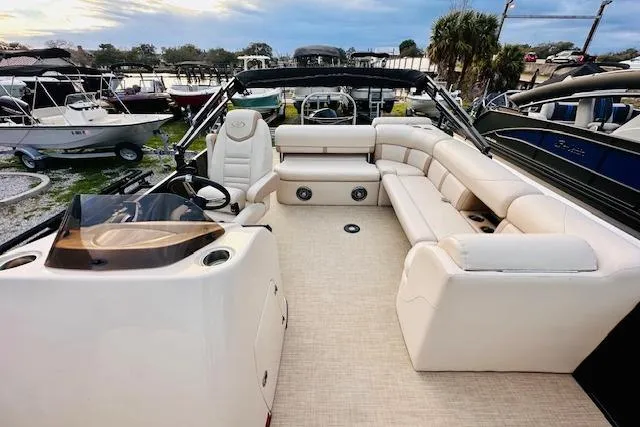 Slide: The Image of 2019 Harris Cruiser 250 boat interior with beige seating and cup holders. - 9