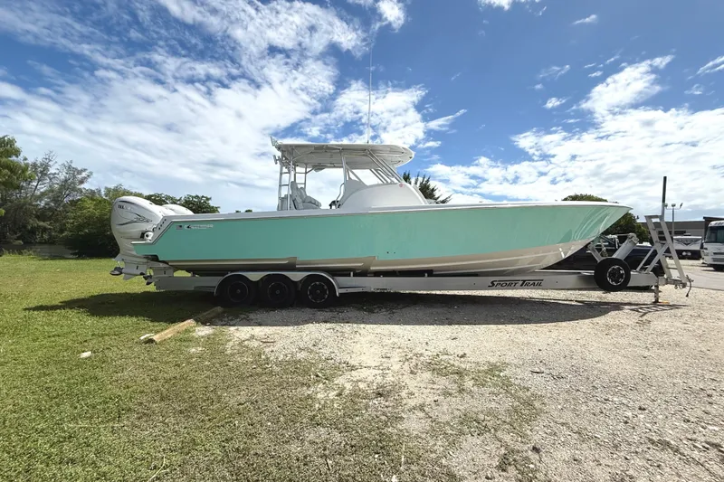 Slide: The Image of 2023 Contender 39 Fisharound boat on trailer under blue sky. - 1