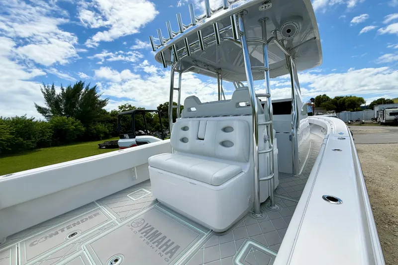 Slide: The Image of 2023 Contender 39 Fisharound boat with sleek design and spacious seating under a blue sky. - 10