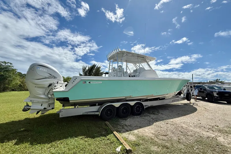 Slide: The Image of 2023 Contender 39 Fisharound boat on trailer, featuring Yamaha engines, under a clear blue sky. - 15