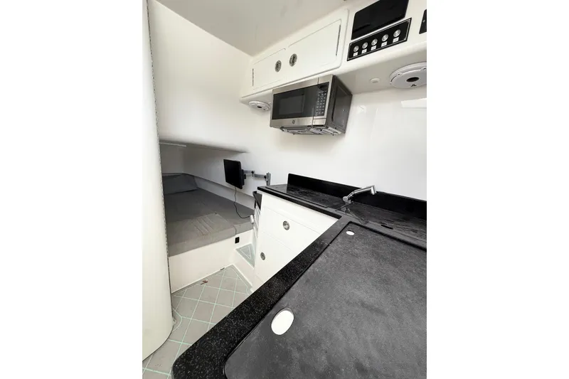 Slide: The Image of 2023 Contender 39 Fisharound cabin with modern kitchenette and sleeping area. - 18