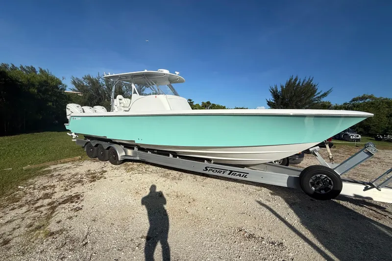 Slide: The Image of 2023 Contender 39 Fisharound boat on trailer, light blue hull, parked outdoors. - 19