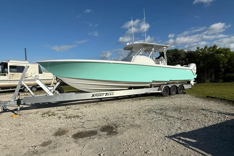 Slide: The Image of 2023 Contender 39 Fisharound boat on trailer under clear blue sky. - 2
