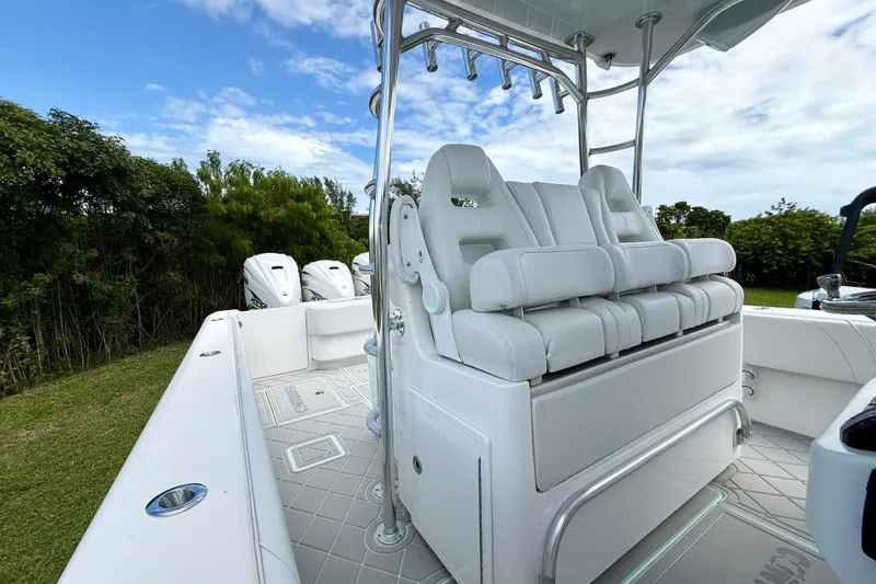 Slide: The Image of 2023 Contender 39 Fisharound boat with white seating and triple outboard engines. - 9