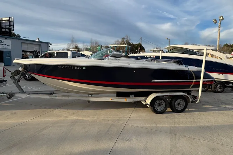 Slide: The Image of 2005 Chris-Craft Launch 22 boat on trailer, parked outdoors under a cloudy sky. - 1